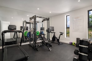Egy modern fitneszterem kardioeszközökkel, súlyemelő állomásokkal és futópaddal.