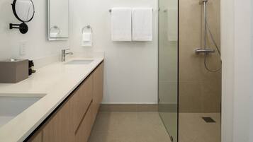 Un bagno moderno con cabina doccia in vetro, lavabo con specchio e porta asciugamani.
