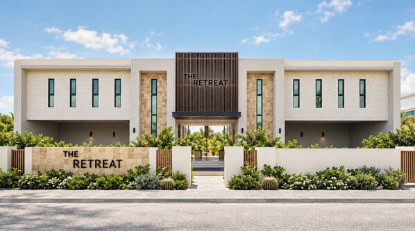 A modern building with a sign reading 'THE RETREAT' at the entrance.