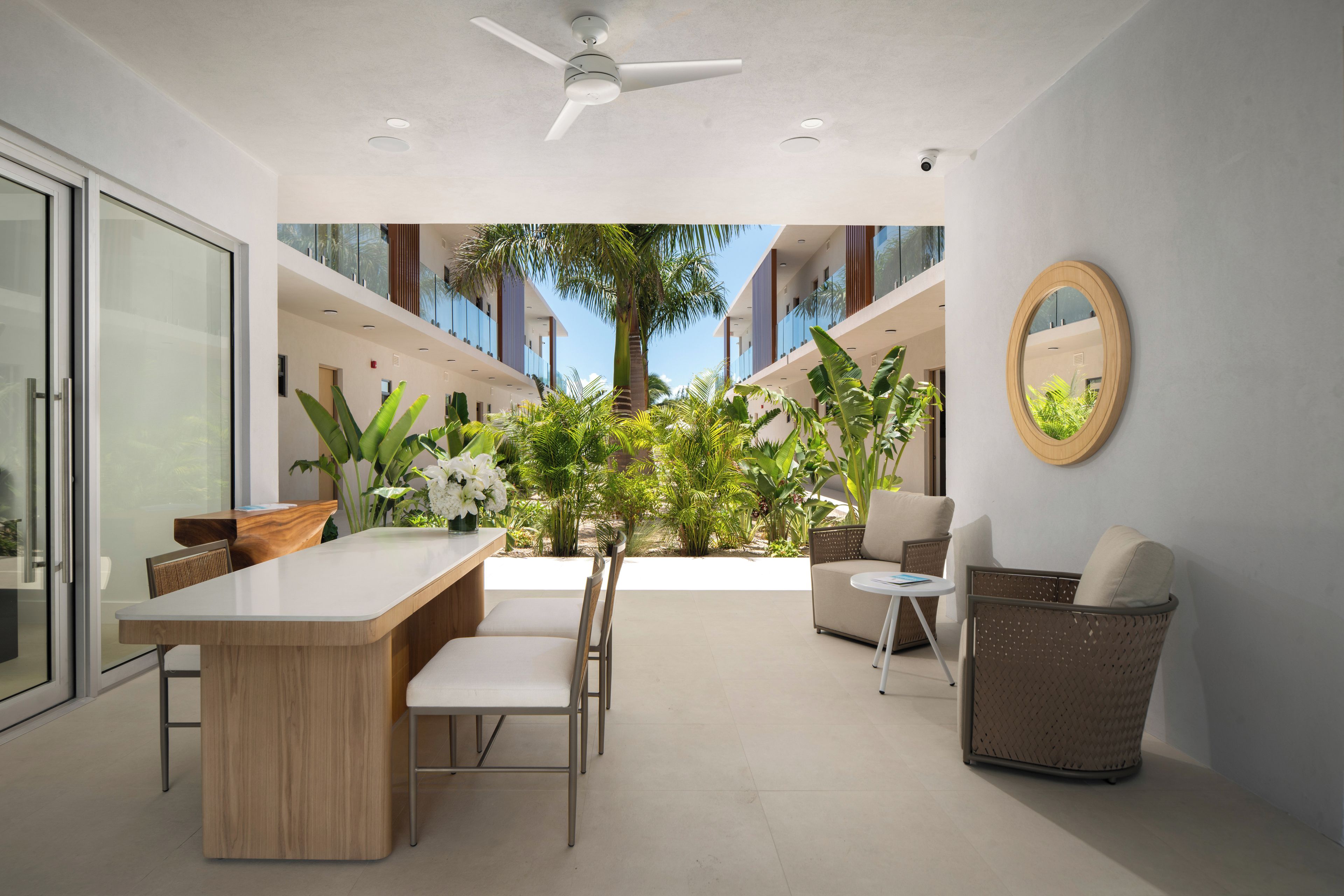Um interior moderno com área de refeições, assentos e vista para o exterior.
