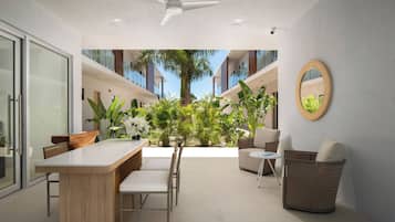 Um interior moderno com área de refeições, assentos e vista para o exterior.