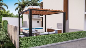 Un espace piscine extérieur moderne, agrémenté d’une pergola en bois, de coins salon et d’un petit espace cuisine.