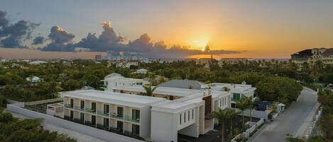 A coastal resort with modern architecture, a marina, and a sunset view.