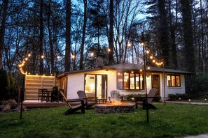 A small house with a deck, outdoor seating, and a fire pit. - The Anchorage - Quiet Stay near Lake Logan (Logan)