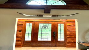A wooden door with a star-shaped window design and a large bullhorn above it. - Peaceful Pond Cottage (Ravenna)
