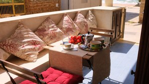 A sunlit outdoor seating area with a table, chairs, and a view of the beach. - VERY NICE RENOVATED APARTMENT JUST 20 METERS FROM THE BEACH! (Donnalucata)