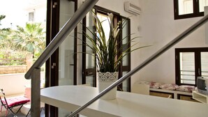 A staircase with a white railing leading to a balcony. A potted plant is on the balcony railing. - VERY NICE RENOVATED APARTMENT JUST 20 METERS FROM THE BEACH! (Donnalucata)