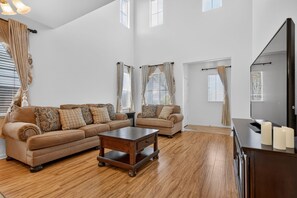 A spacious living room with two sofas, a coffee table, and a TV.