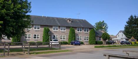 A two-story motel with a flat roof, multiple windows, and a parking lot.