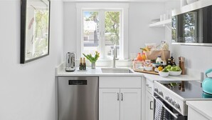A modern kitchen with a dishwasher, double sink, and a stove.