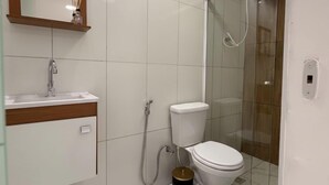 A modern bathroom with a toilet, sink, and shower.
