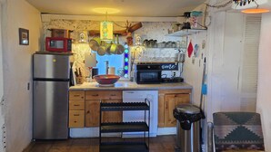 A compact kitchen with a refrigerator, microwave, and coffee machine. - Cozy 2-bedroom cabin on a working mini farm in San Fidel with AC on old route 66 (San Fidel)