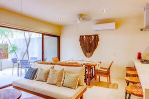 A modern dining area with a wooden table set for four, surrounded by comfortable seating. - Luxury Jungle Condo in Tulum with Pools, Private Cenotes & Gated Community (Tulum)