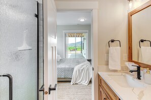 A modern bathroom with a large mirror, a sink with a faucet, and a towel rack. - 5 Min From Lava Hot Springs, close to golf course & private Hot Tub (Lava Hot Springs)