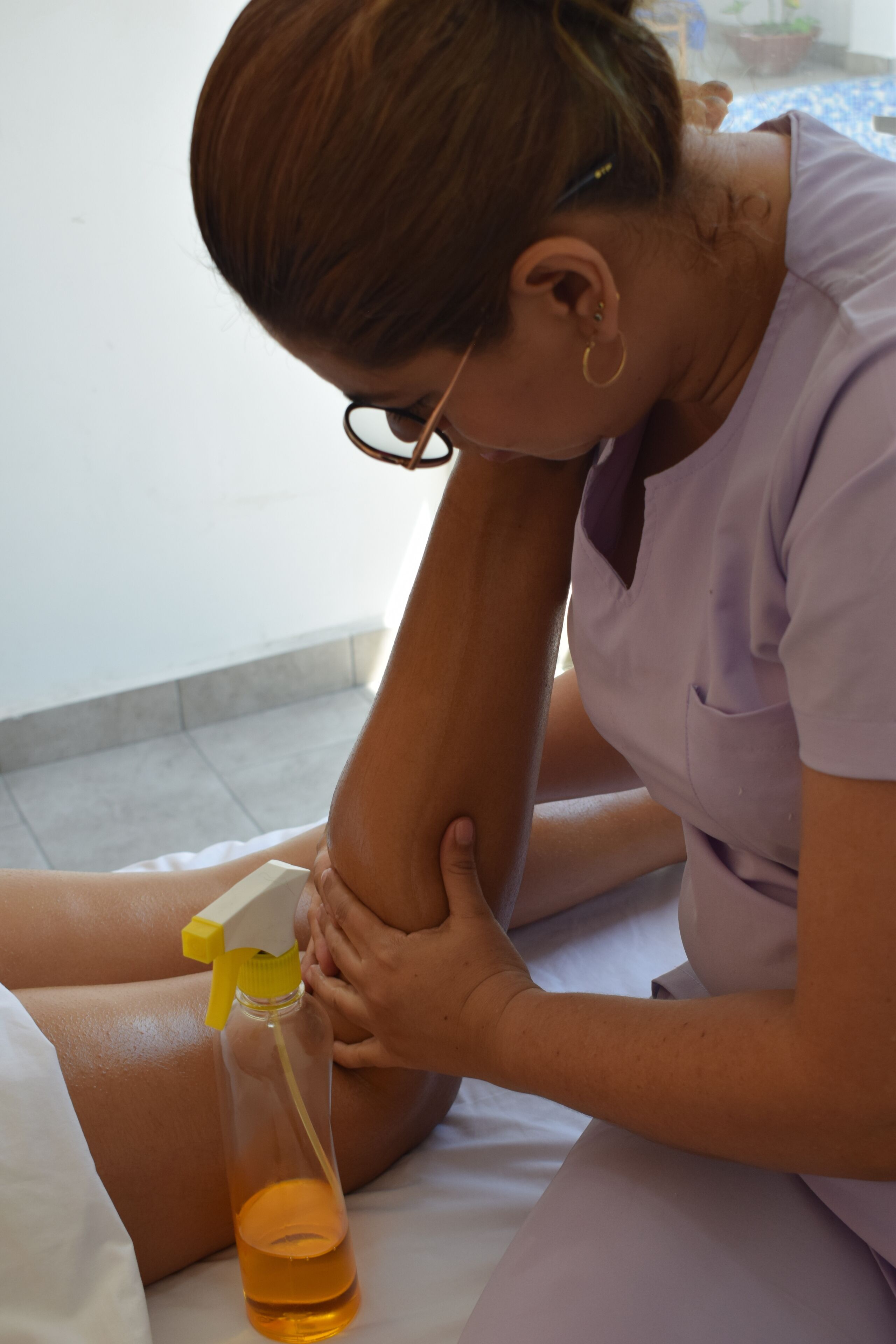 A person applying a substance to another person's leg.