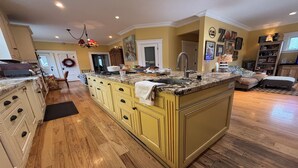 Una cocina amplia con una isla grande, armarios de madera y un horno empotrado.