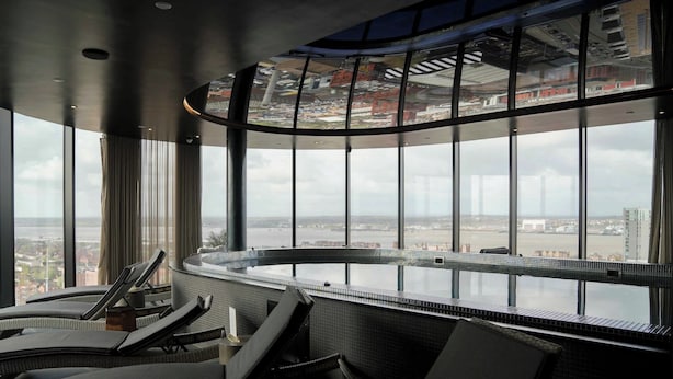 Een moderne lounge met een panoramisch uitzicht over de stad door grote ramen.