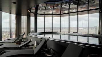 A modern lounge area with a panoramic view of the city through large windows.