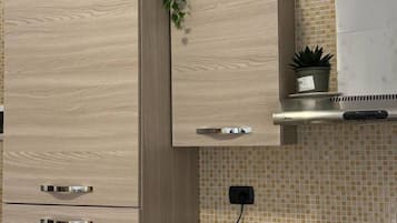 A kitchen with wooden cabinets, a stainless steel range hood, and a tiled backsplash.