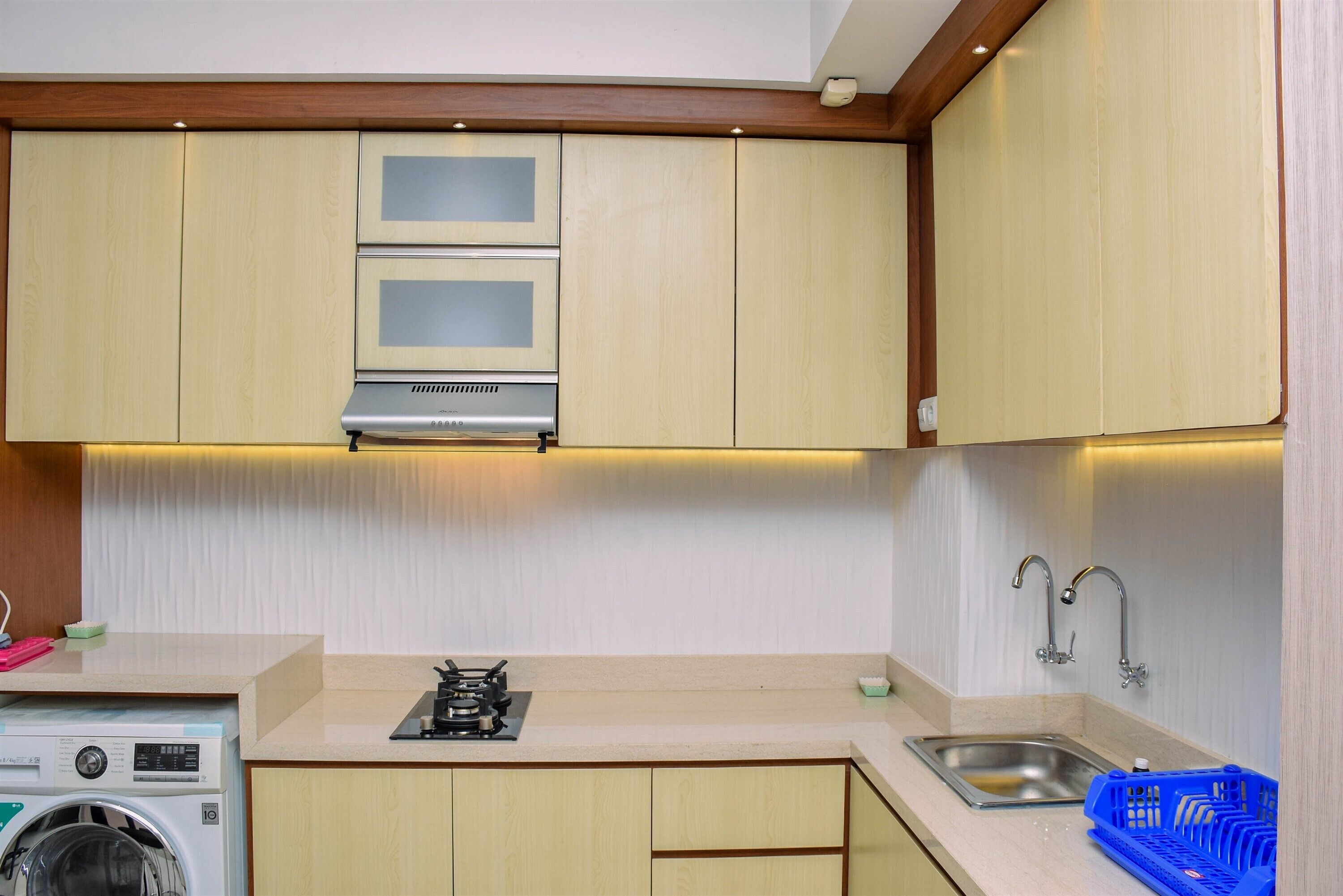 A compact kitchen with a built-in washing machine, a gas stove, and a sink.