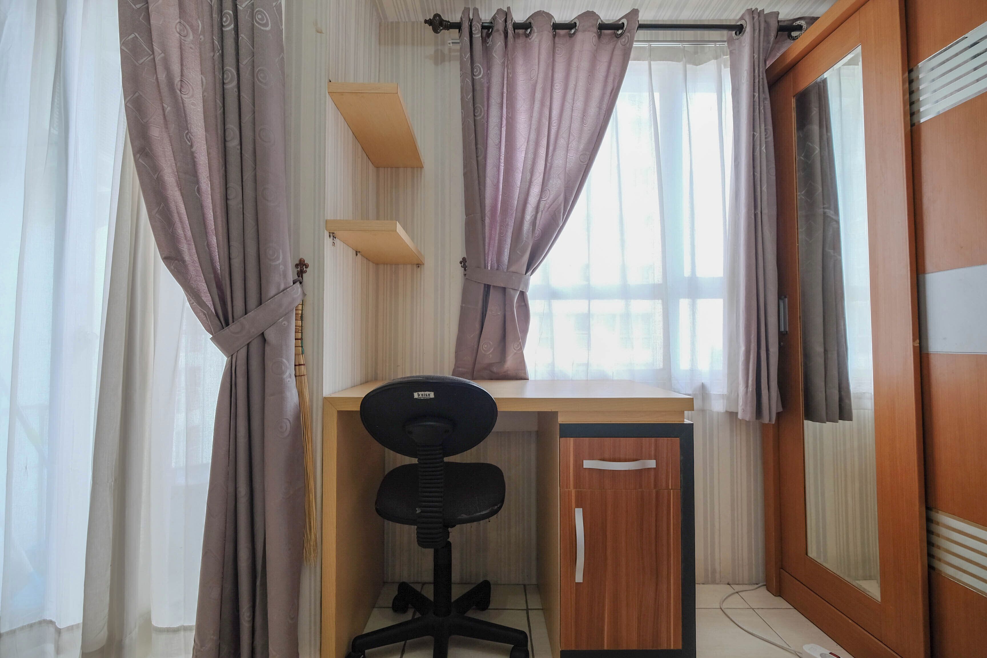 Una habitación con escritorio, silla y armario.