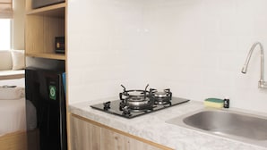 Een kleine keuken met een gasfornuis, een spoelbak en een magnetron.