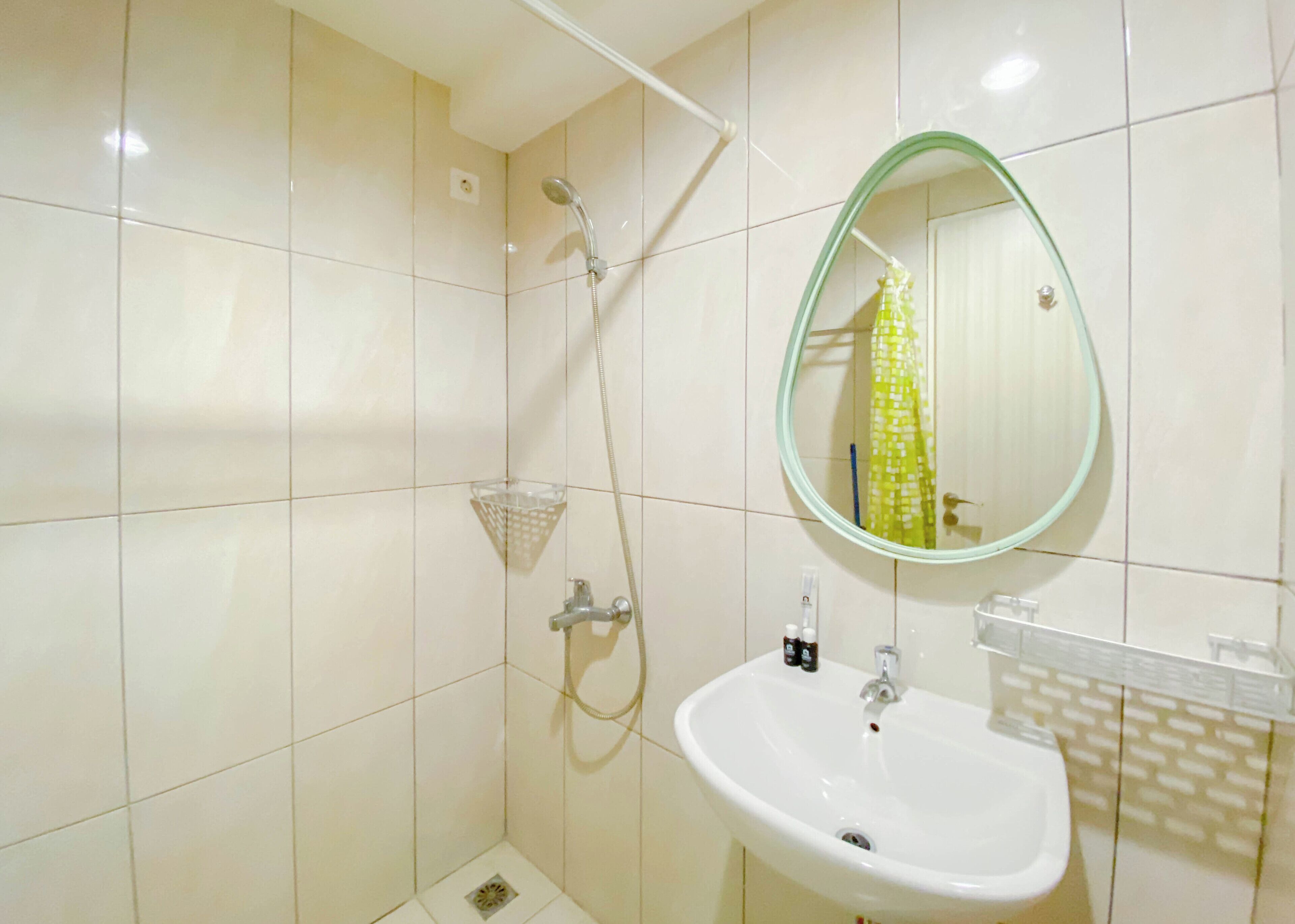 A bathroom with a shower, a sink, and a mirror.