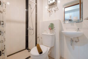 Une salle de bain avec des toilettes, une douche et un lavabo.