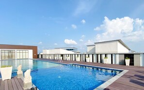 A rooftop swimming pool with modern buildings in the background. - Cozy And Neat Studio At Cleon Park Apartment (Jakarta)