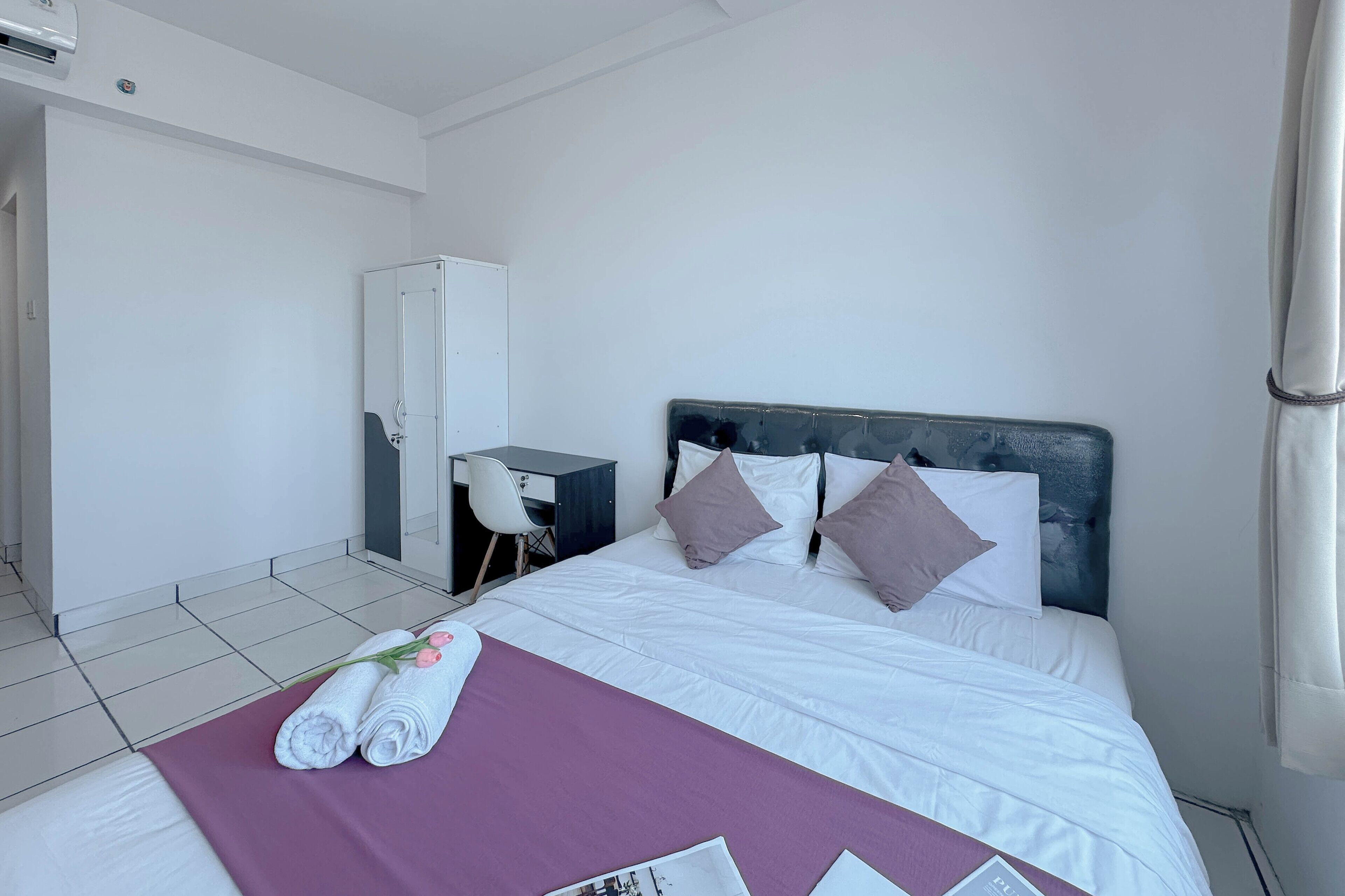 Una camera d'albergo con un letto, una scrivania e un armadio.