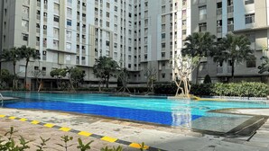 A residential building with a swimming pool. - Warm And Comfy 2Br At Green Bay Pluit Apartment (Jakarta)