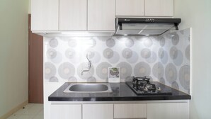 Une cuisine équipée d’une cuisinière à gaz, d’un évier et d’un crédence décorée.