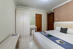 Ein Hotelzimmer mit Bett, Schreibtisch, Kleiderschrank und Bad.