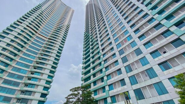 Two high-rise buildings with a modern architectural design, featuring a grid of windows and balconies. - Elegant And Homey Studio At Grand Kamala Lagoon Apartment (Bekasi)