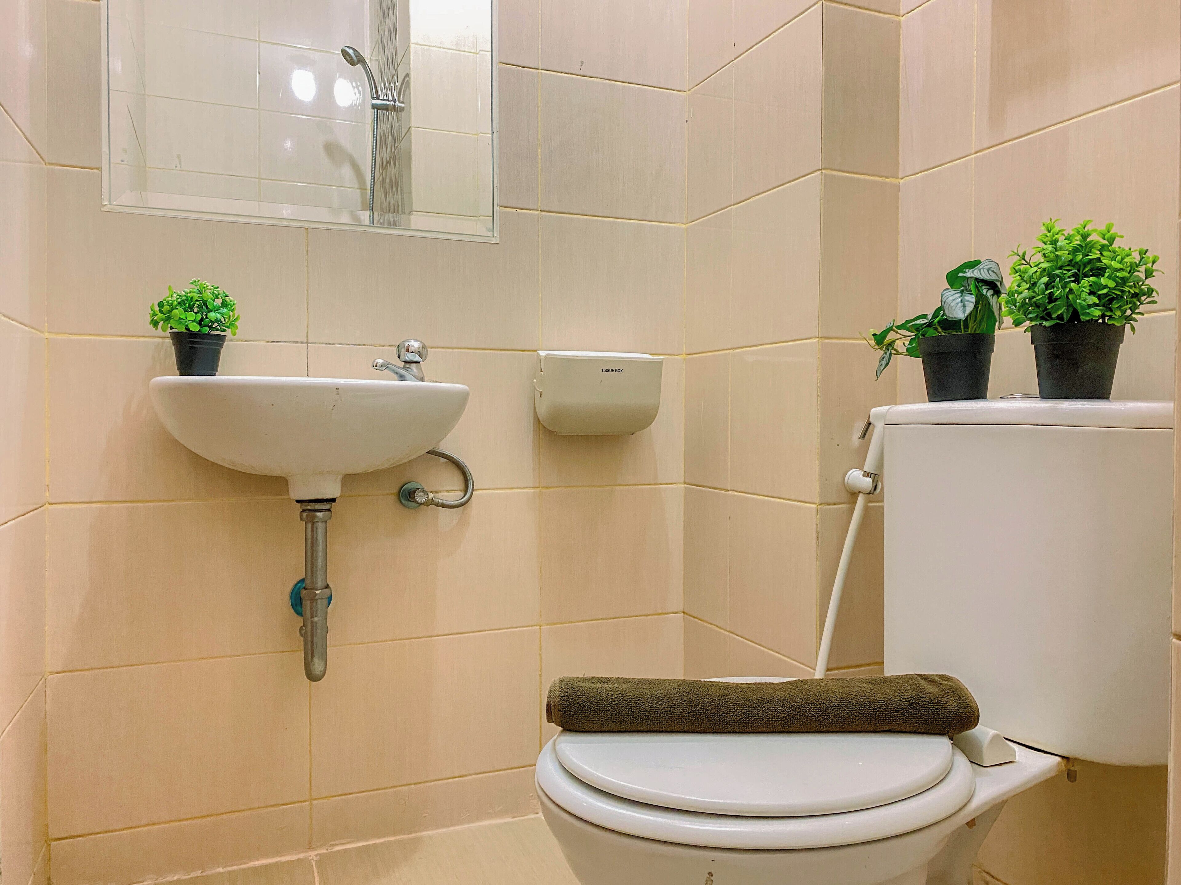 Ein Badezimmer mit Toilette, Waschbecken und Spiegel.