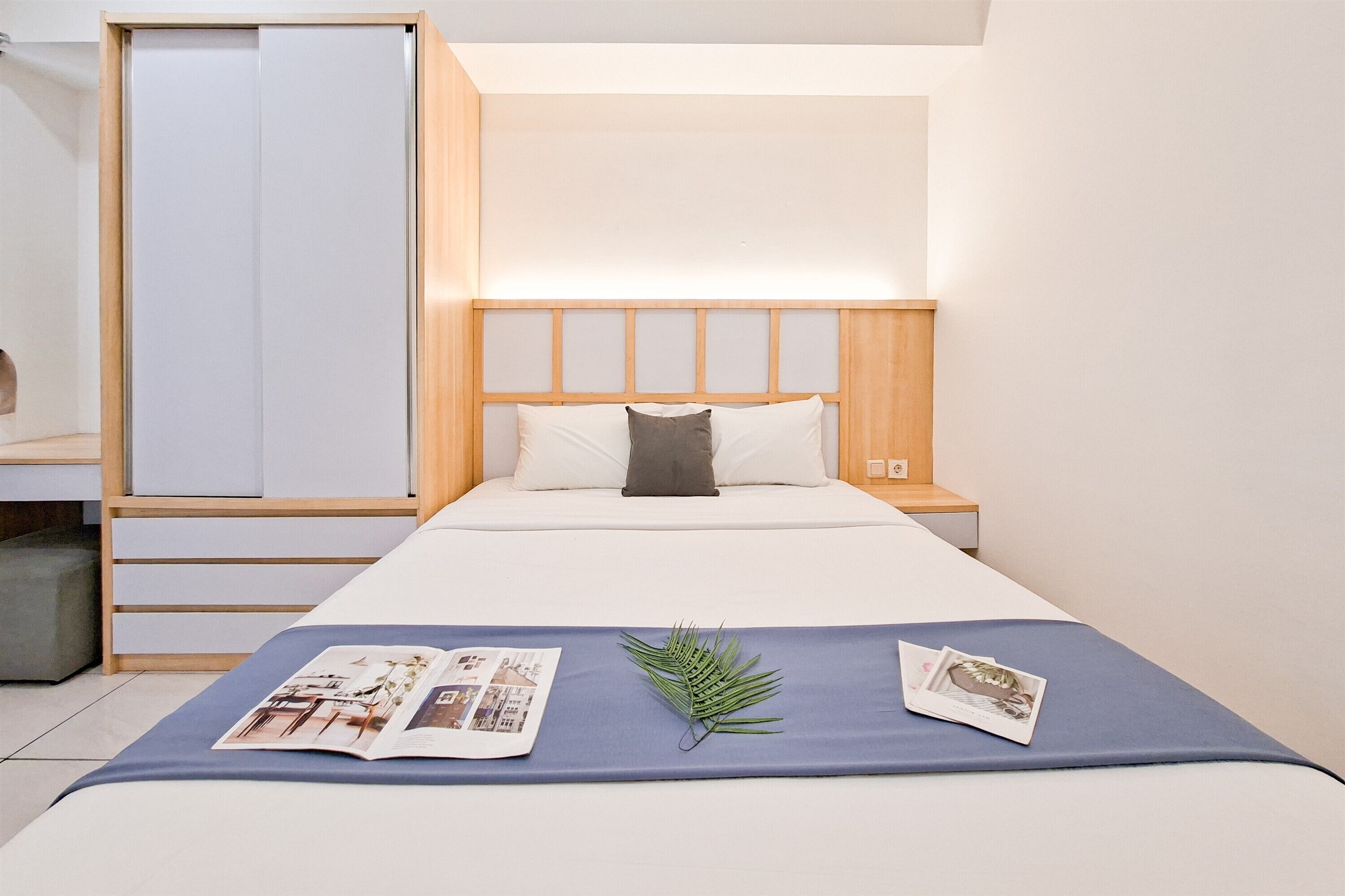 Habitación de hotel ordenada con cama, armario y mesita de noche.
