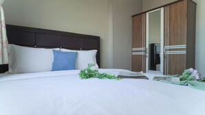 A hotel room with a bed, a wardrobe, and a mirror. - Enjoyable Spacious 2Br Space At Apartment Teluk Intan (Jakarta)