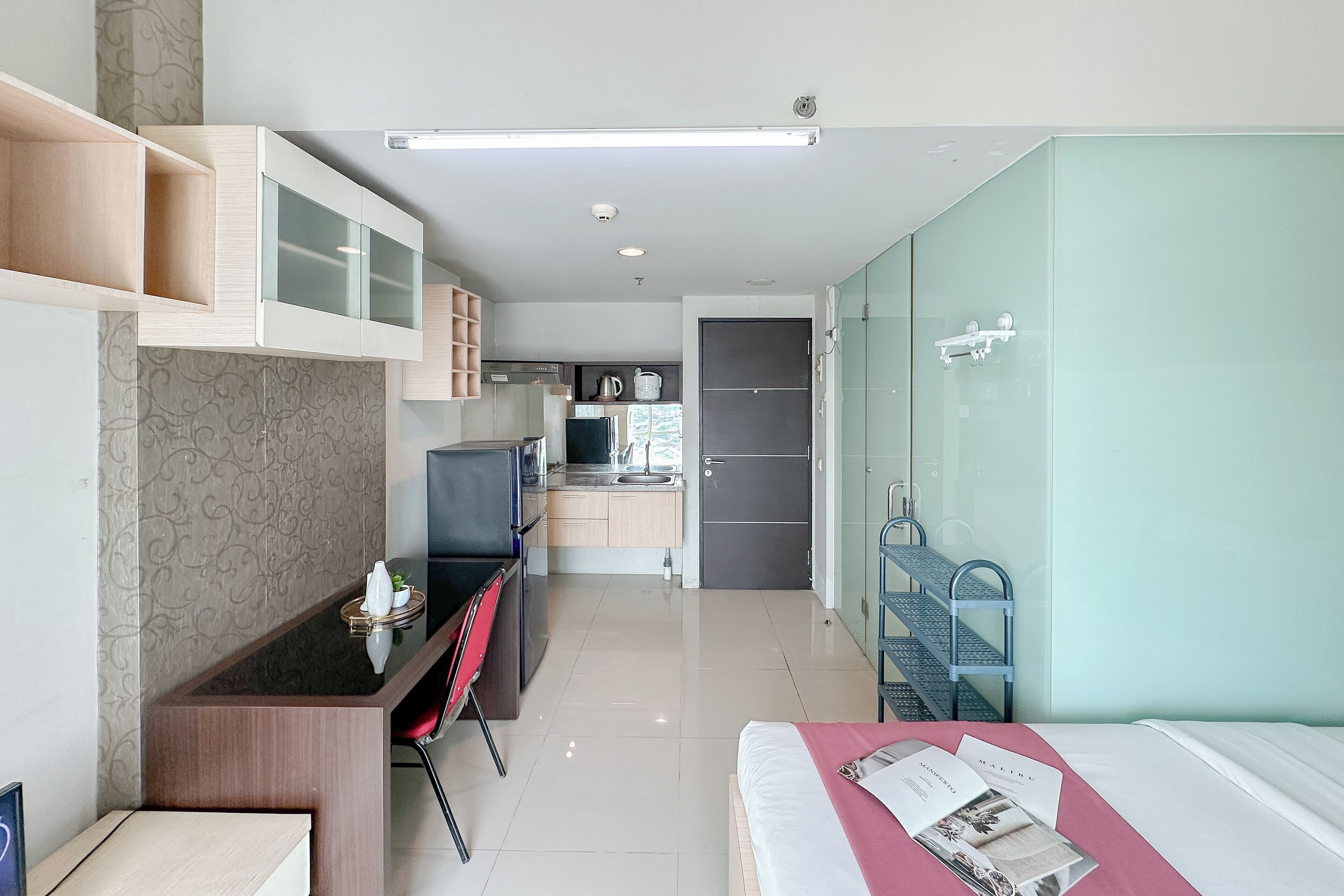 Una habitación de hotel moderna con cama, escritorio y kitchenette.