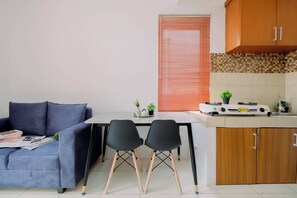 A compact kitchen with a dining area, a sofa, and a small table with chairs. - Strategic 1Br Apartment At Marina Ancol (Jakarta)