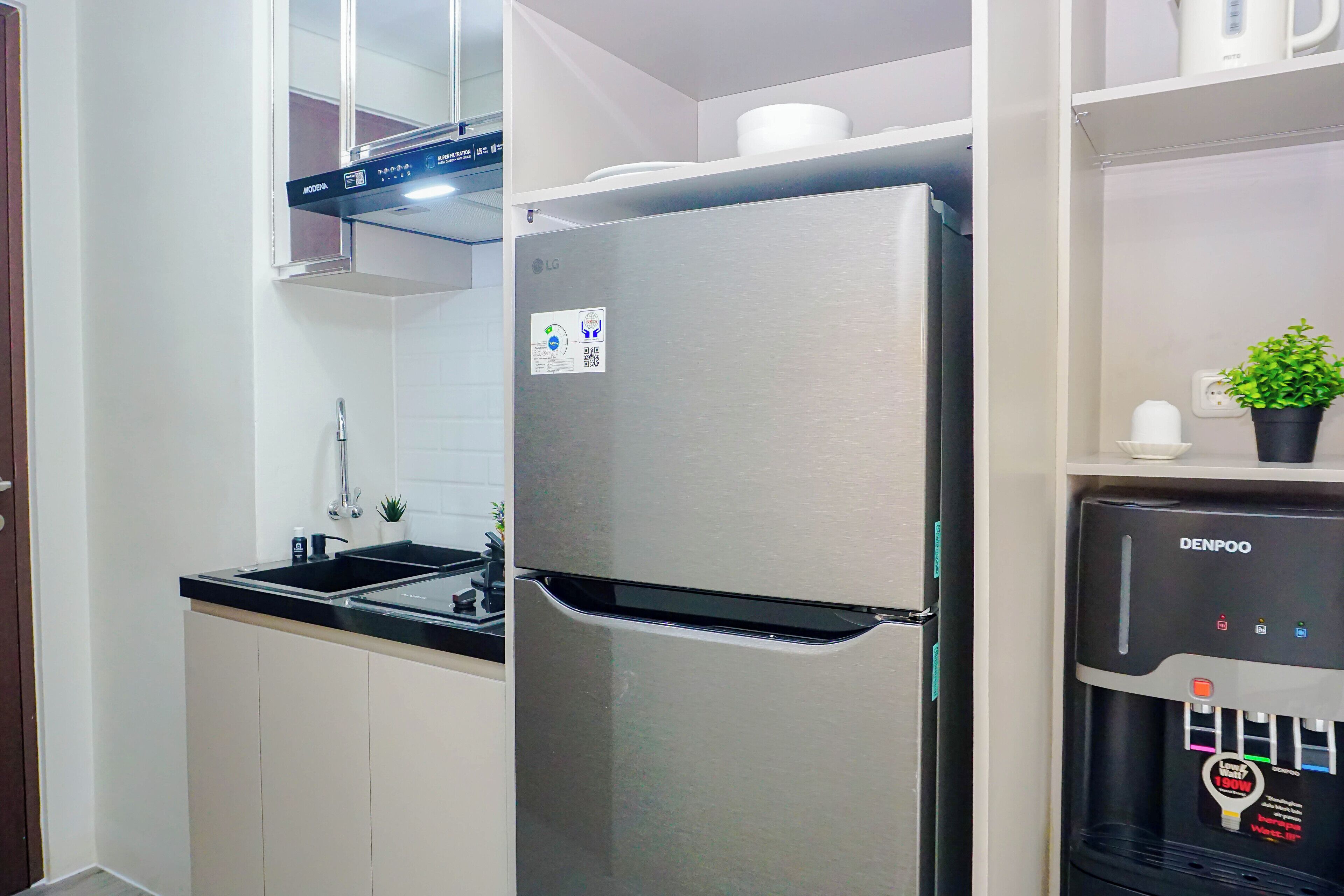 A kitchen with a stainless steel refrigerator, a sink, and a water dispenser.