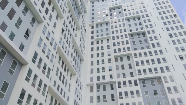 Een hoog gebouw met een raster van ramen en balkons.