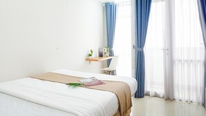 Une chambre d’hôtel avec un lit, un bureau et une fenêtre avec des rideaux.