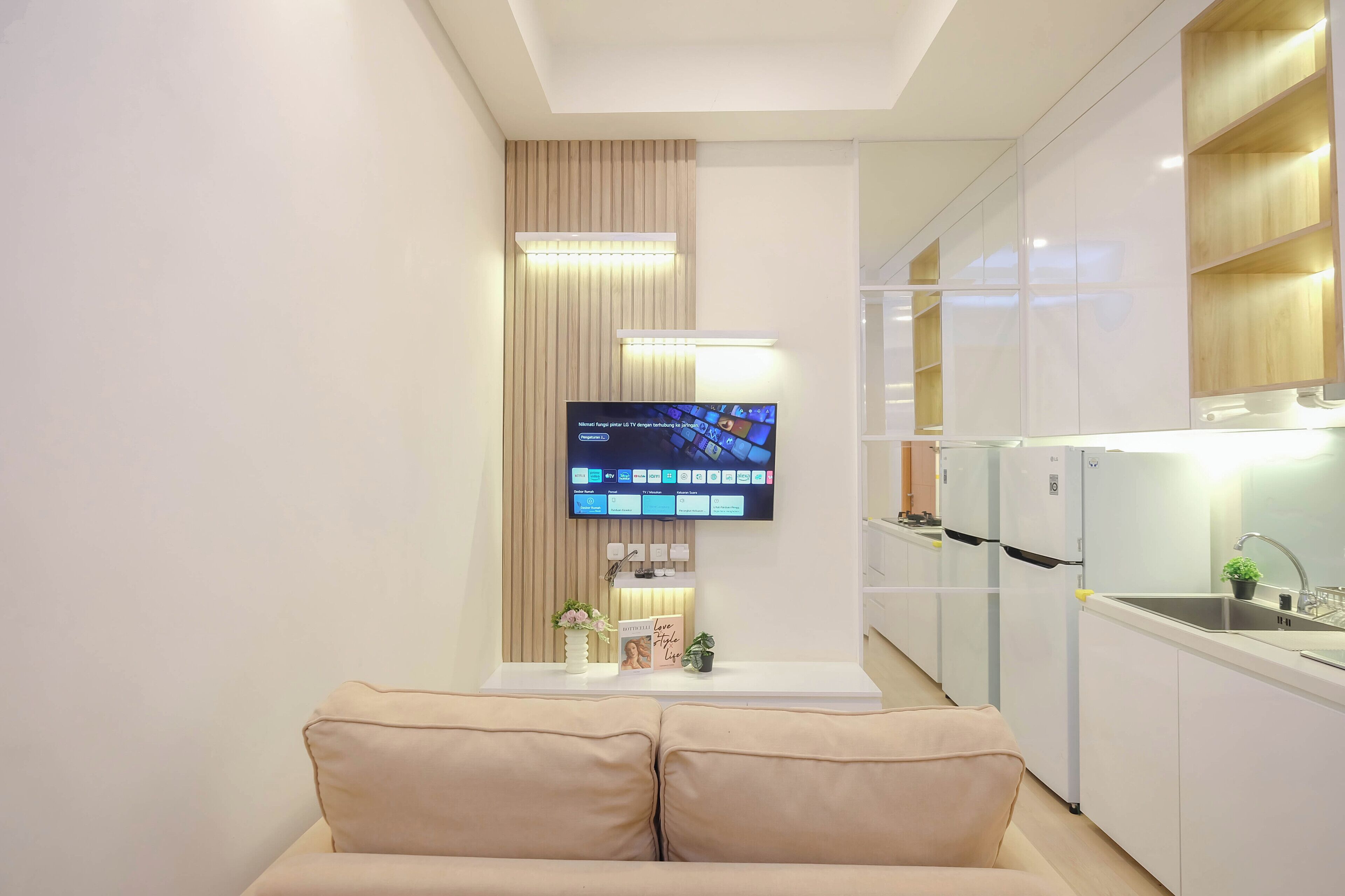 A modern kitchen with white cabinets, a built-in oven, and a refrigerator.