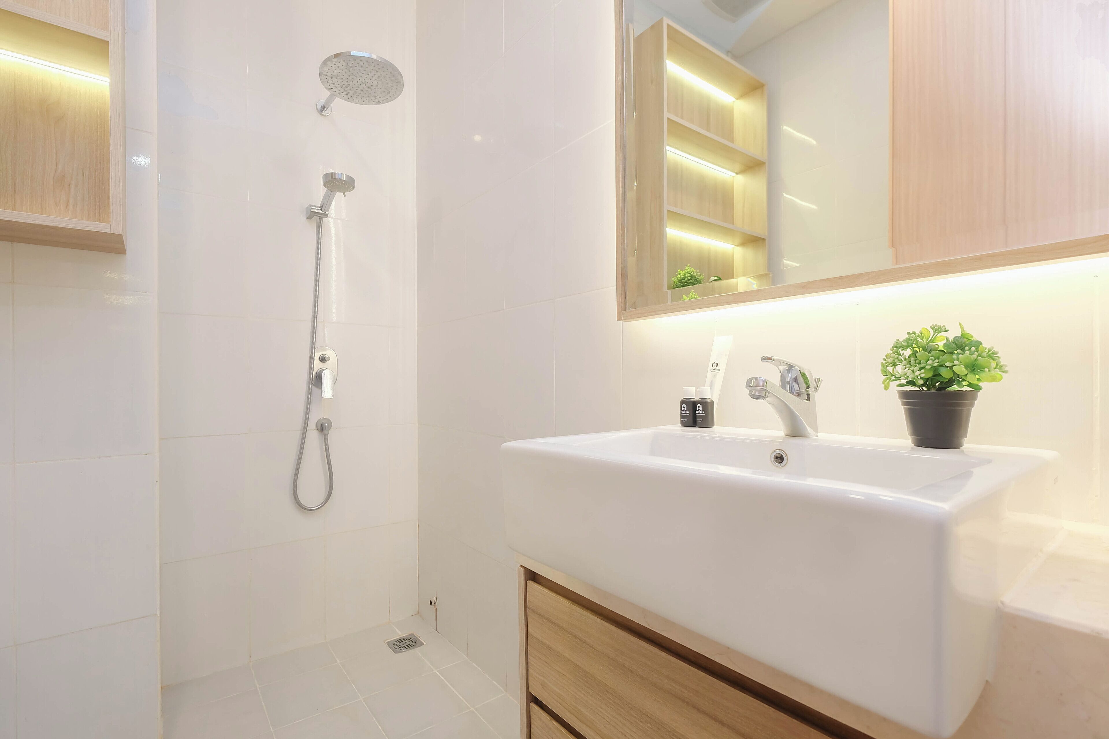 Ein modernes Badezimmer mit Dusche, Waschbecken und Spiegel.
