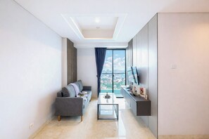 Ein modernes Wohnzimmer mit einer Couch, einem Couchtisch und einem Fernseher an der Wand.