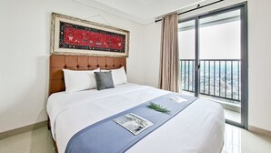 Une chambre d’hôtel avec un grand lit, une œuvre d’art encadrée au-dessus du lit, un balcon avec vue et une fenêtre avec des rideaux.