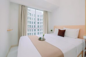 A hotel room with a large bed, a bedside table, a window with curtains, and a view of a building outside. - Compact And Stylish 2Br Near Nice At Tokyo Riverside Pik 2 Apartment (Teluknaga)