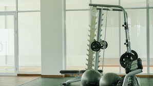 Ein Fitnessraum mit Kraftstation, Übungsbällen und einem großen Fenster.