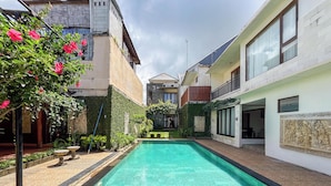 A rectangular swimming pool with a clear blue water surface, surrounded by a stone border. - Spacious And Homey 3Br At Villa Casa De Uli (Jimbaran)