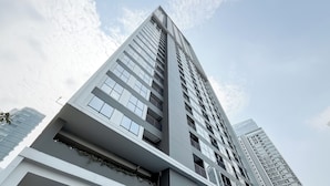 A modern high-rise building with multiple floors, large windows, and balconies. - Chic And Comfortable Studio At Apartment Ciputra World 2 (Jakarta)